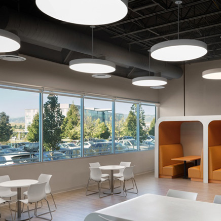Pendant lights hanging in cafe with white tables and orange booths