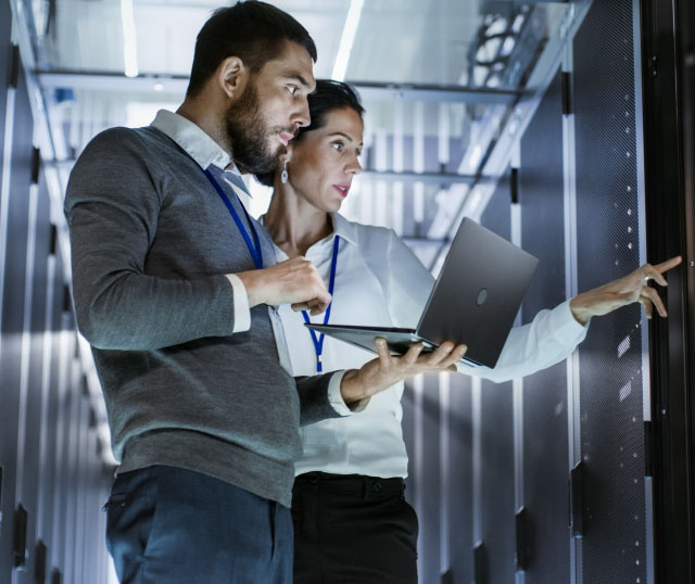 2 people in data center with a computer