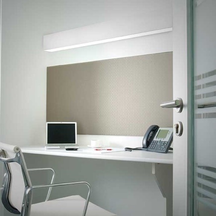 Office space with wall lighting, laptop, and work phone