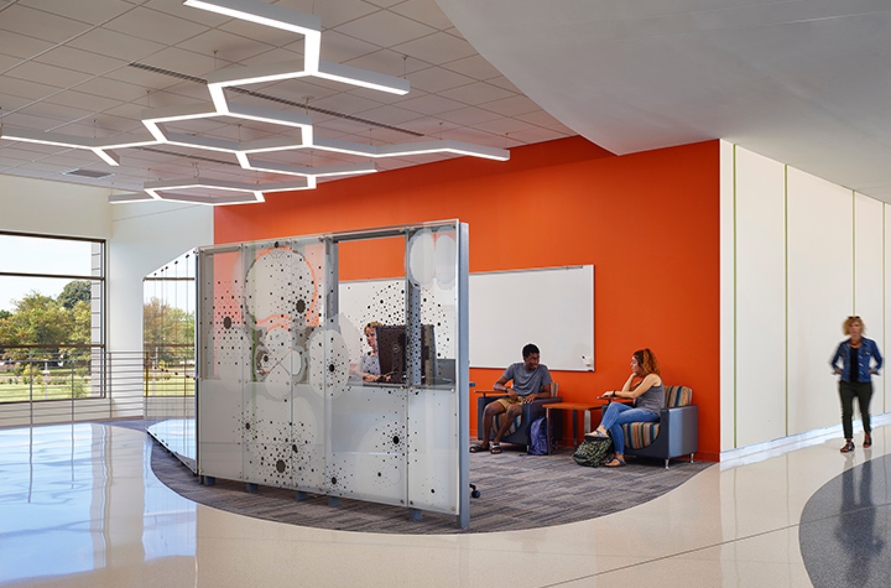 Orange wall and students hanging out in an open space