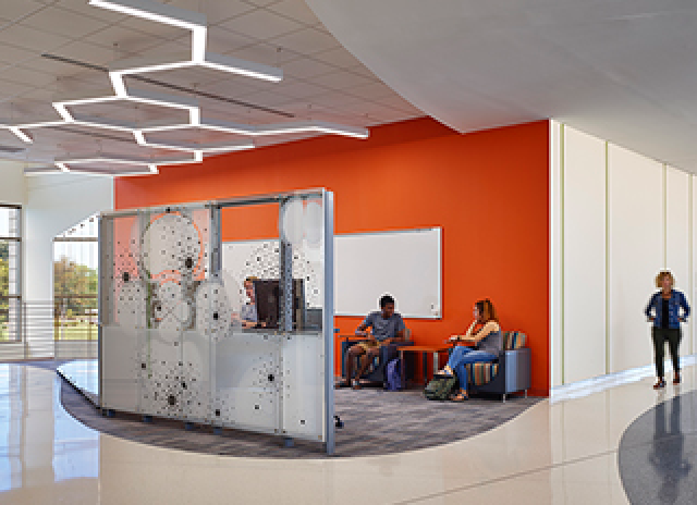 Orange wall and students hanging out in an open space